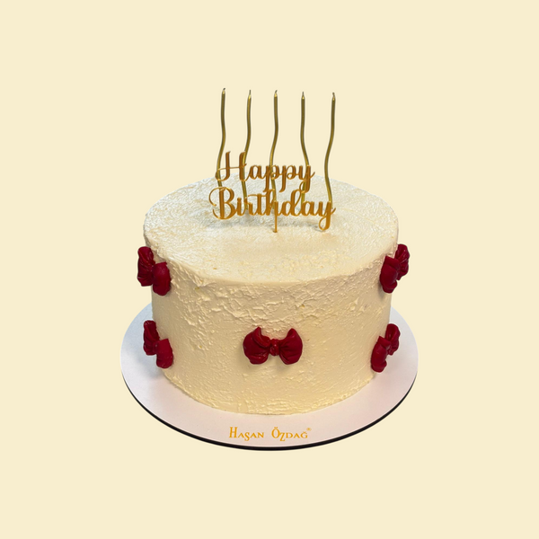 Geburtstagstorte mit roten Schleifen und Goldkerzen