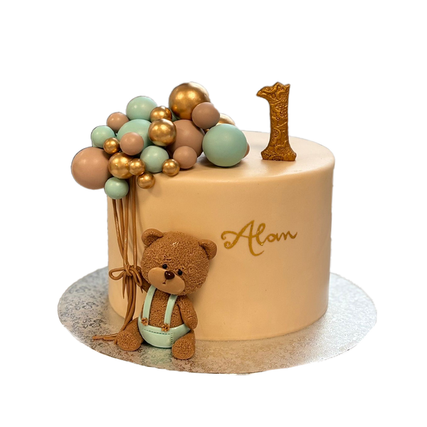 Beige Bärchentorte mit Kugeln in blau, beige und gold. Zudem gibts nen Teddy in Latzhose