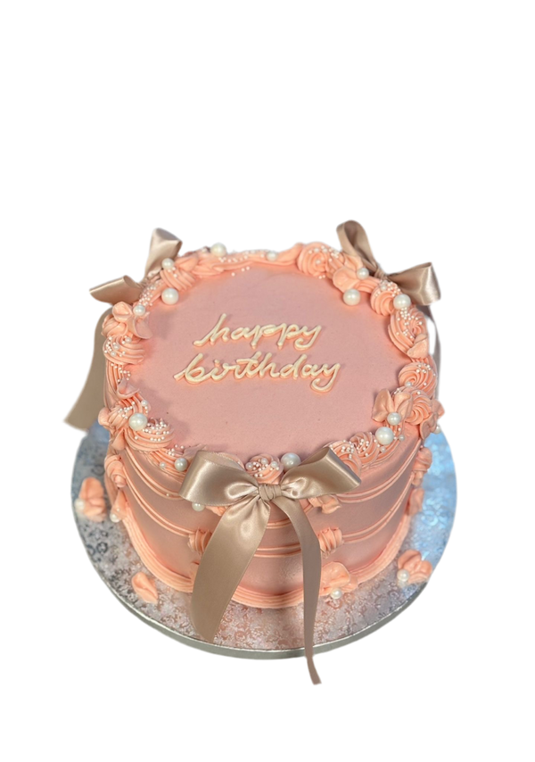 Runde Torte in Rosa mit Perlen und Schleifen