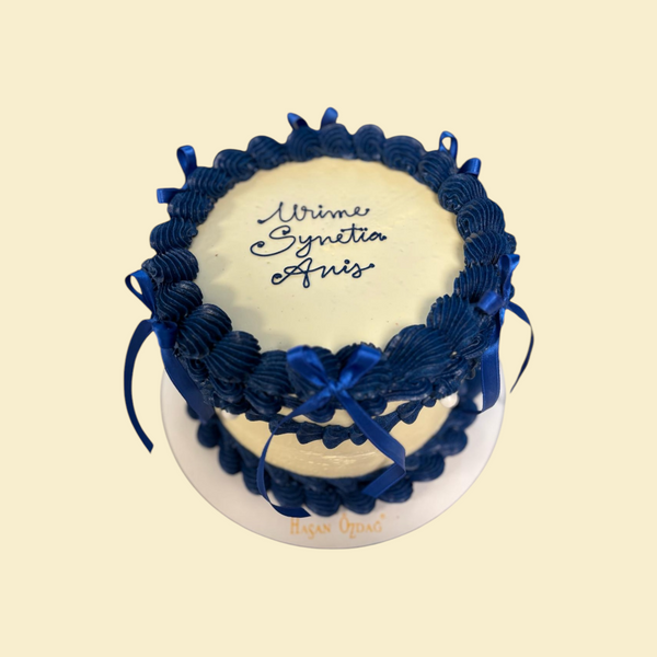 Runde Buttercreme Torte mit Blauer Spritzdeko und Schleifen
