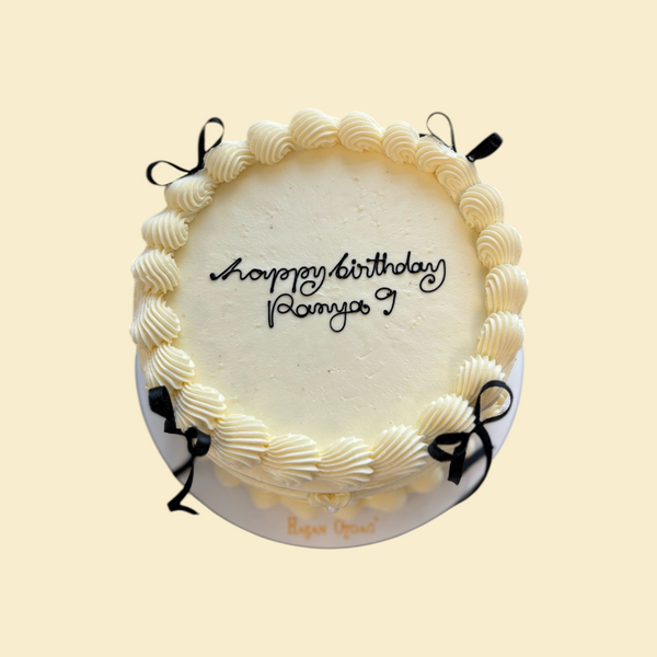 Runde Buttercreme Torte mit Schrift und Schwarzen Schleifen
