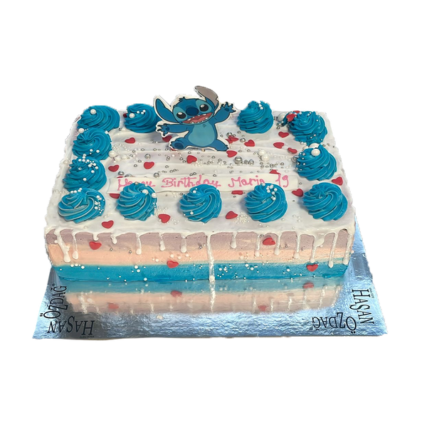 "Rechteckige Stitch-Geburtstagstorte mit blauen Buttercreme-Rosetten, Herz-Streuseln, weißer Drip-Dekoration und einer Stitch-Figur als Topper. Perfekt für Kindergeburtstage oder Disney-Motto-Partys."