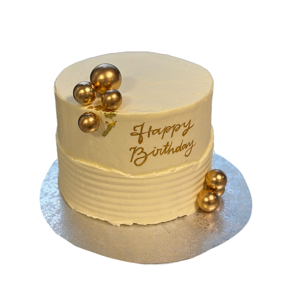 Weiße Torte mit Struktur mit Goldkugeln