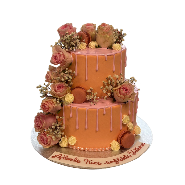 Zweistöckiger rosa Drip-Cake mit rosa drip, Macarons, Schleierkraut und Rosen