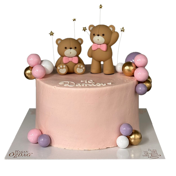 Rosa Bärchen-Torte mit pastellfarben und goldenen Kugeln