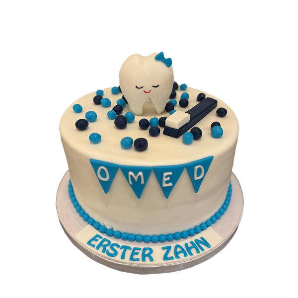 Weiße Zahntorte mit Zahn, Zahnbürste und Kugeln. Die Torte hat zudem eine blaue Dekoration.