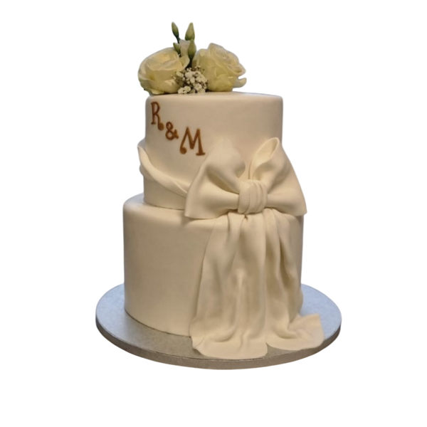 2 Etagen Torte mit großer weißer Schleife und weißen Rosen personalisiert