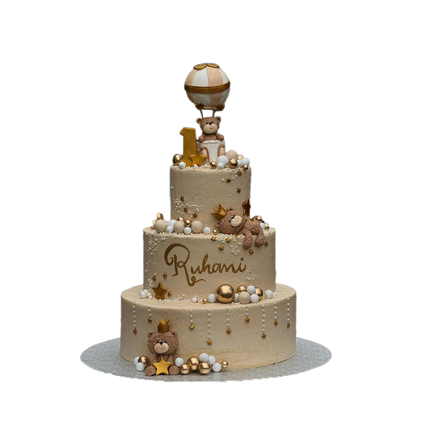 3 stöckige, beige Torte mit Kugeln, Sternchen, Perlen und Bärchen . Ein Bär sitzt in einem Ballon, die anderen beiden tragen eine Krone