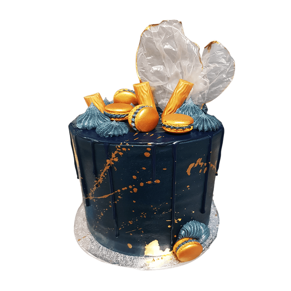 Blaue Torte mit Goldspritzern, goldenen Macarons und Schokoriegel