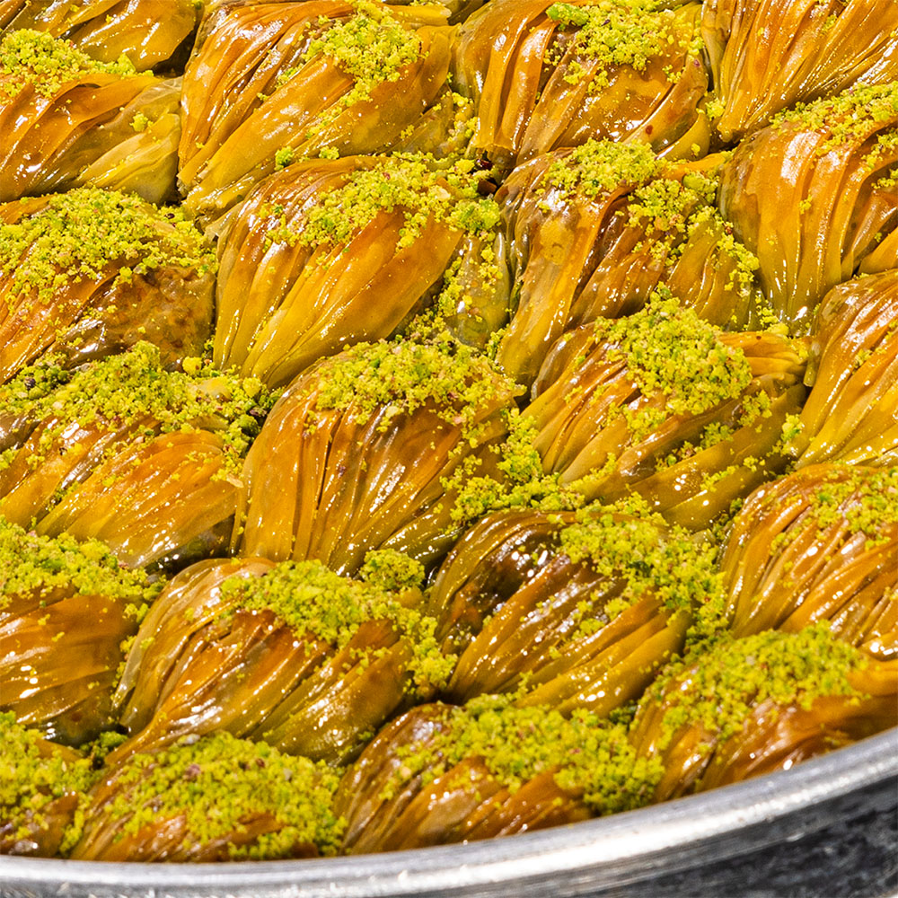 Midye-Baklava mit Cremefüllung und bestreuten Pistazien – traditionelles Dessert in Muschelform.