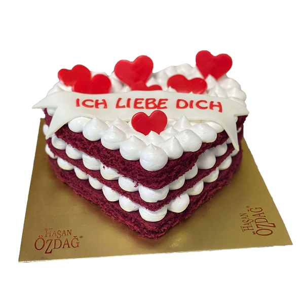 Herzförmiger Red-Velvet-Cake mit Sahnehäubchen, Textbanner und Fondant-Herzen