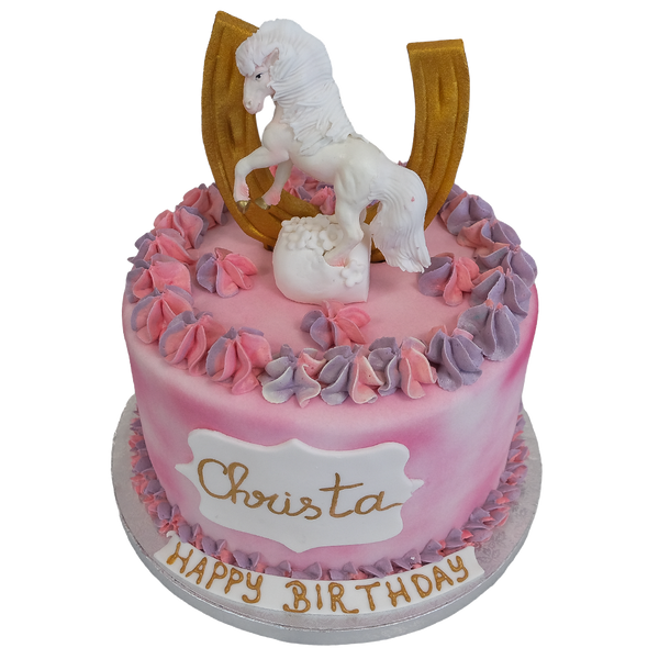 Rosa torte mit rosa-lila Spritzdeko und Ponyfigur mit  goldenen Hufeisen