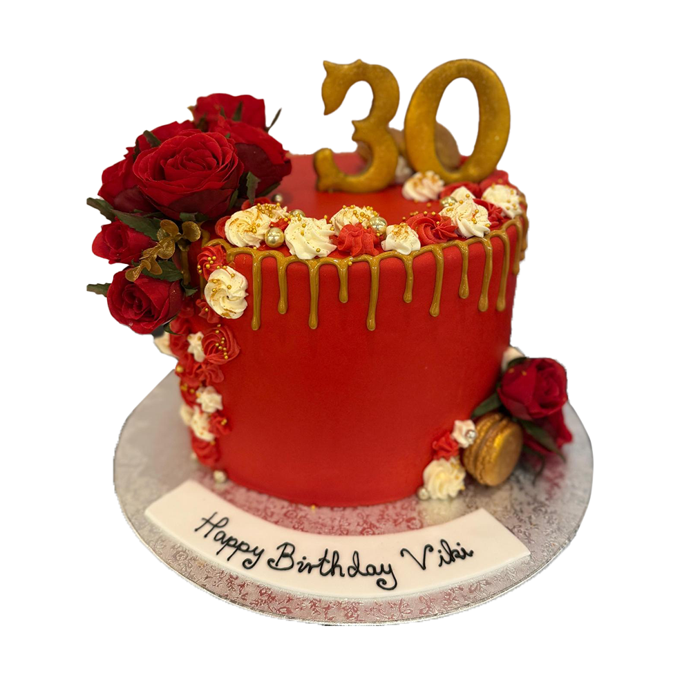 Roter Drip Cake mit  weißer Spritzdeko, goldenen Macarons und roten Rosen
