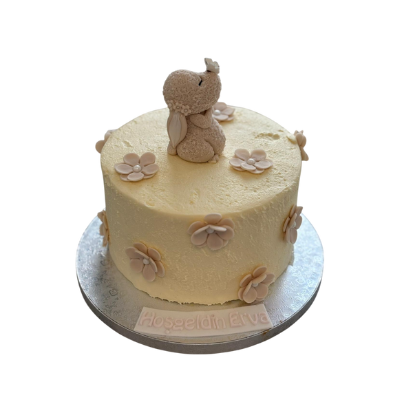 "Handgefertigte Baby-Torte mit zartem Elefanten aus Fondant auf einer cremigen Buttercreme-Torte, verziert mit Blüten und personalisiertem Schriftzug