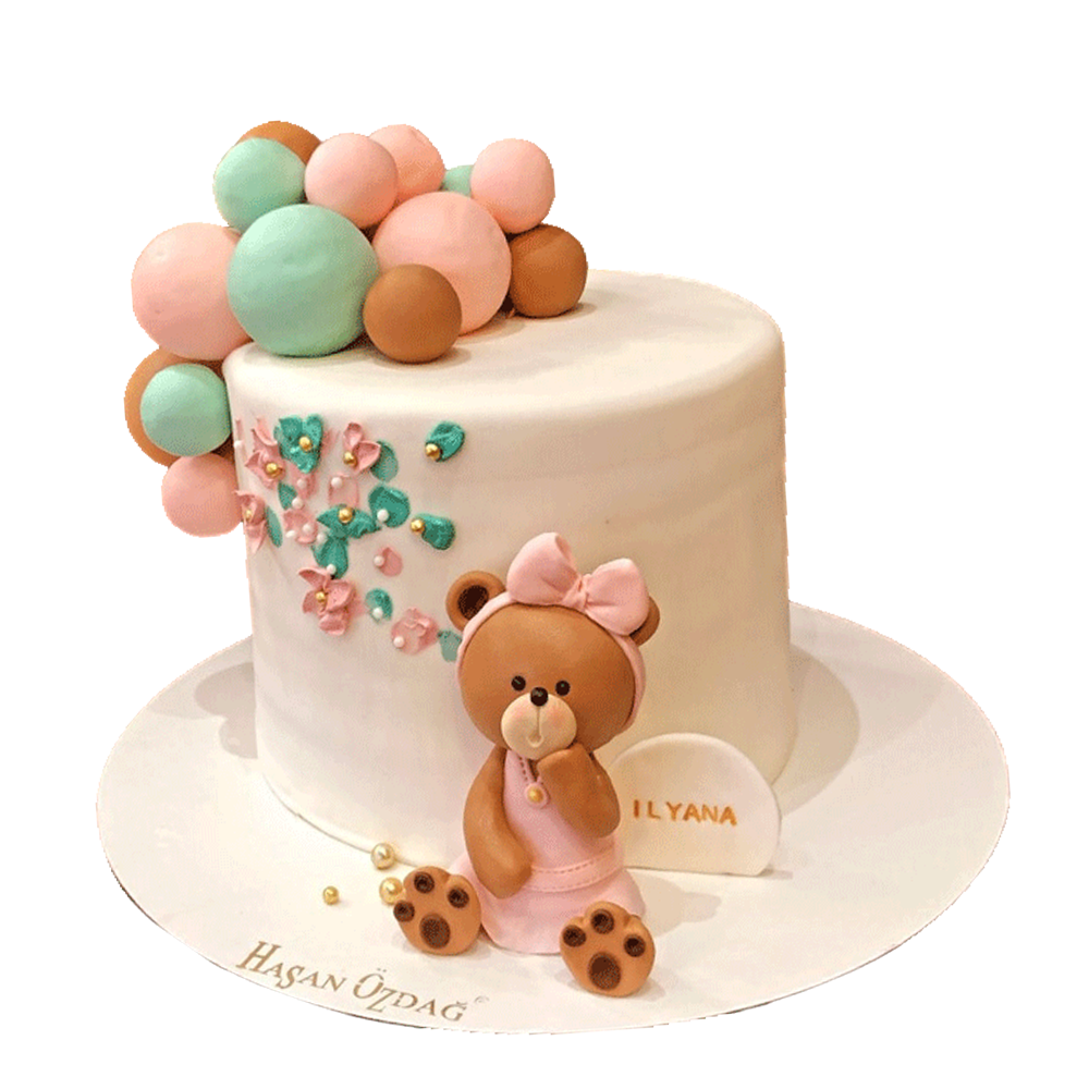 apricotfarbende Teddytorte mit Kugeln in rosa, braun und mint.  Die Torte hat rosa und mintfarbende Spritzer mit Perlen und Bärchen-Figur.