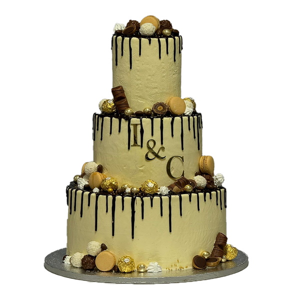 Beige Drip Torte mit Schokodrip und diversen Süßigkeiten. Diese Süßigkeiten sind Rocher, Macarons, Bueno, Toffifee und Raffaelo